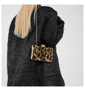 Fashionable leopard print acrylic evening clutch with gold chain on model's shoulder
