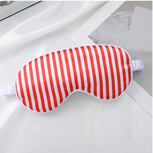 Close-up detail of the red and white striped silk sleep mask, soft and comfortable for night rest.