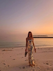 Detailed view of shimmering gold sequins on a backless evening dress at sunset
