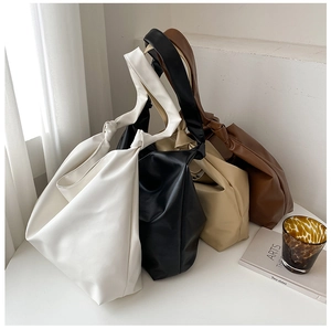 Detail of four large faux leather tote bags in white black beige and brown with knotted straps