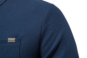 Detail of blue waffle texture fabric and metallic badge on the men's long sleeve T-shirt