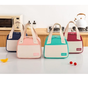 Front view of four colorful insulated trapezoid lunch bags on a kitchen counter