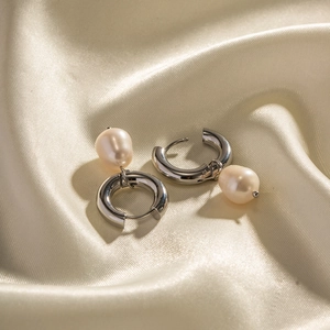 Elegant stainless steel hoop earrings with natural freshwater pearl drops on silk fabric