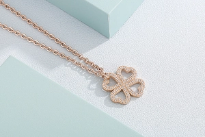Macro view of rose gold four-leaf clover necklace pendant set with sparkly zircons