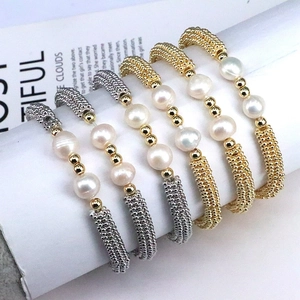 Detail of handcrafted gold and silver bracelets with pearls and metallic beads