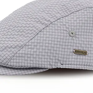 Detail of grey checkered beret showing high-quality fabric texture and metal brand tag