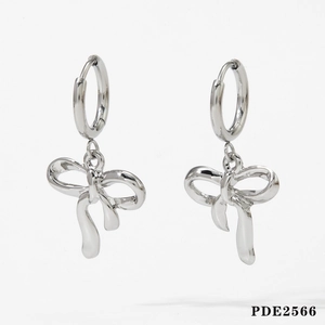 Detailed close-up of silver bow pendant earrings with polished metallic finish