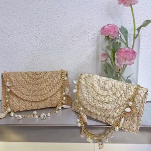 Handwoven straw shoulder bag with elegant shell pearl gold chains for beach vacation