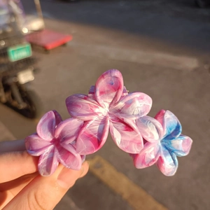 Close-up of floral hair claw clip featuring gradient petals and a marble texture resin finish