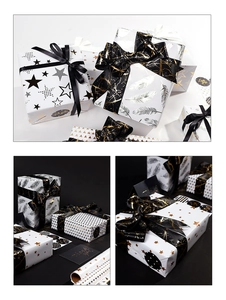 Detail view of gold stamped star patterns on black and white gift wrapping paper set