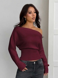 Détail d'un pull en maille côtelée bordeaux à épaules dénudées avec taille cintrée