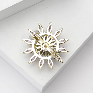 Detailed back view of snowflake brooch showing the safety pin and gold metal base