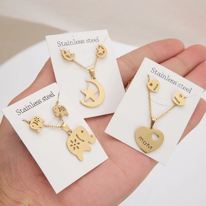 Handheld gold stainless steel necklace and earring set featuring star, moon, and heart designs