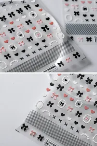 Detailed 5D embossed nail stickers featuring pearl bows and heart patterns on a white background