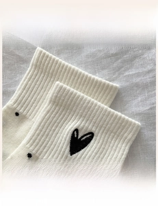 Detailed close-up of high-elasticity ribbed sock cuff with heart and polka dot patterns
