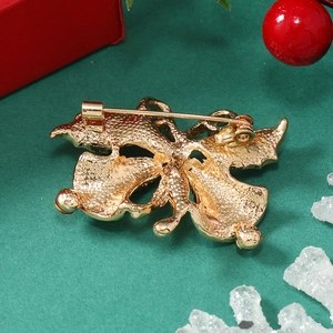 Detail of the pin fastener on back of gold Christmas bell brooch with bow design