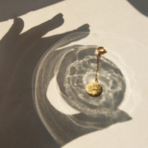Detailed view of 18k gold stainless steel eye pendant with artistic water ripple lighting