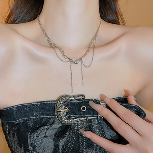 Detail of silver tassel necklace with draped chains styled on a vintage denim corset top