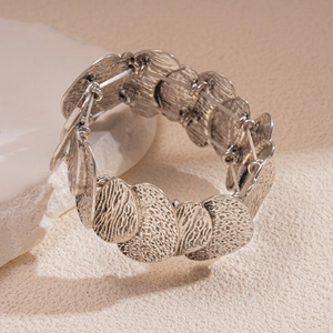 Detailed view of silver textured metallic discs on elastic cord minimalist bracelet