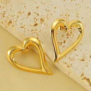 Orecchini a perno a cuore cavo in oro 18 carats su elegante sfondo beige testurizzato
