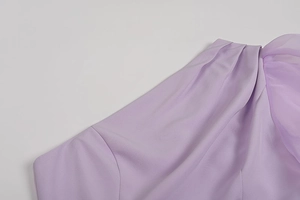 Detail of purple one-shoulder dress showing pleated chiffon stitching and neckline texture