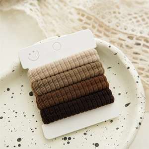 Detail of high-elastic seamless hair ties in gradient brown tones on a display card