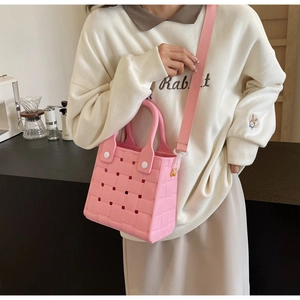 Detail view of pink EVA beach bag with woven texture, detachable strap and white rivets
