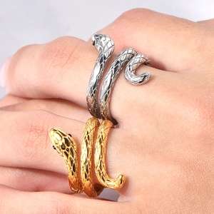 Close-up of gold and silver snake rings with scale texture and snake head design