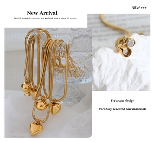 Detail of gold-plated snake chain necklace with magnetic clasp and heart pendant