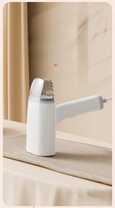 Detail view of portable handheld steam iron with L-shaped handle and transparent tank