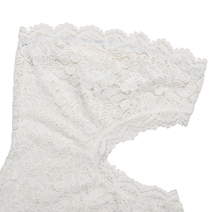 Dettaglio ravvicinato della trama in pizzo bianco e del motivo floreale del vestito