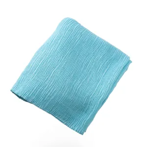 Detail of light blue pleated cotton scarf fabric with vertical accordion pleats texture
