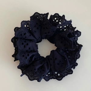 Détail d'un chouchou en dentelle double épaisseur avec broderies florales ajourées