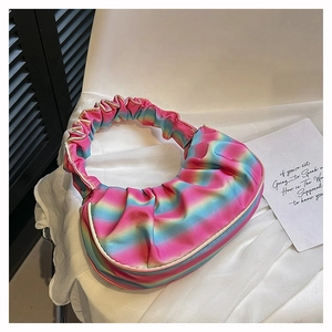 Rainbow gradient pleated dumpling bag with satin finish on a white chair detail