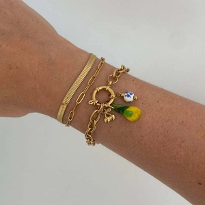 Detailed shot of triple-layered gold bracelet set with lemon and cherry charms