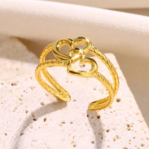 Detail of adjustable gold-plated twisted band ring featuring double heart motifs