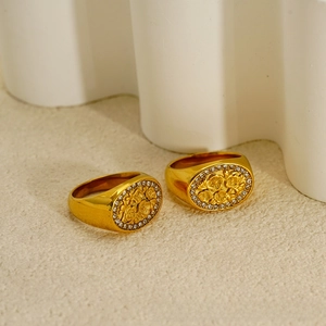 Detail eines 18K vergoldeten Siegelrings mit Blumenrelief und weißen Schmucksteinen