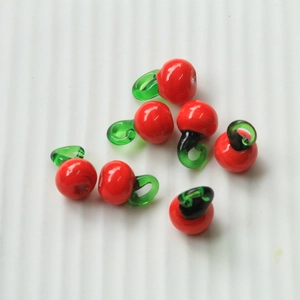 Detailed view of red cherry-shaped glass beads for DIY jewelry making and crafts