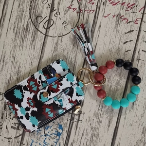 Detail showing silicone beaded bracelet keychain with floral print card wallet and tassel