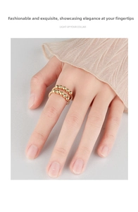 Close-up of a double-layer gold spinning ring with ten beads on a woman's hand