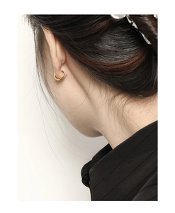 Detail view of small 10mm gold hoop earrings on model for a minimalist jewelry look