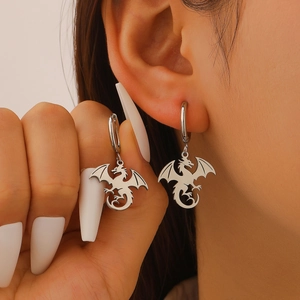 Gros plan de boucles d'oreilles dragon en argent avec ailes détaillées sur un modèle