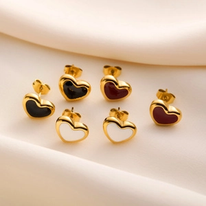 Detailed macro view of heart-shaped gold studs in black, red, and white on silk