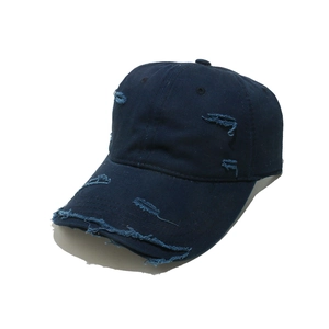 Close-up of distressed indigo denim baseball cap with vintage worn holes and frayed edges