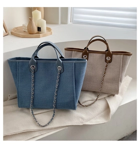 Bolsos bombonera de lona azul y beige con correas de cadena bajo luz natural cálida