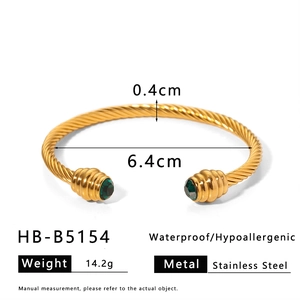 Detail view of gold twisted stainless steel cuff bracelet with green gemstones and dimensions