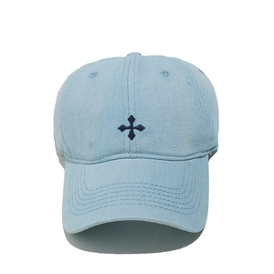 Détail de la broderie en croix sur une casquette de baseball en denim bleu clair