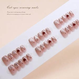 Detail of short square cat-eye press-on nails with red heart and silver star patterns