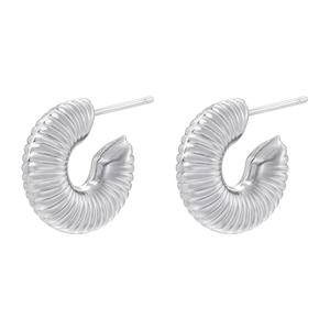 Macro detail of silver C-shaped croissant earrings with textured spiral ridges and push-back pins
