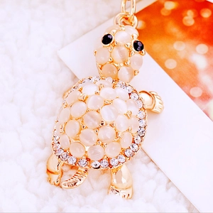 Macro shot of golden turtle keychain with moonstone beads and sparkling rhinestones